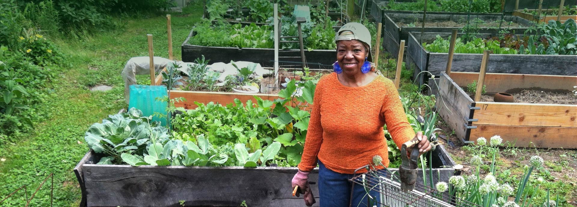 Woman standing in garden with tools