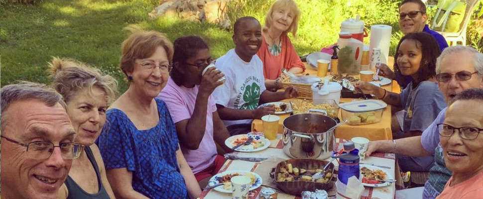 photo: people seated at a picnic table with food