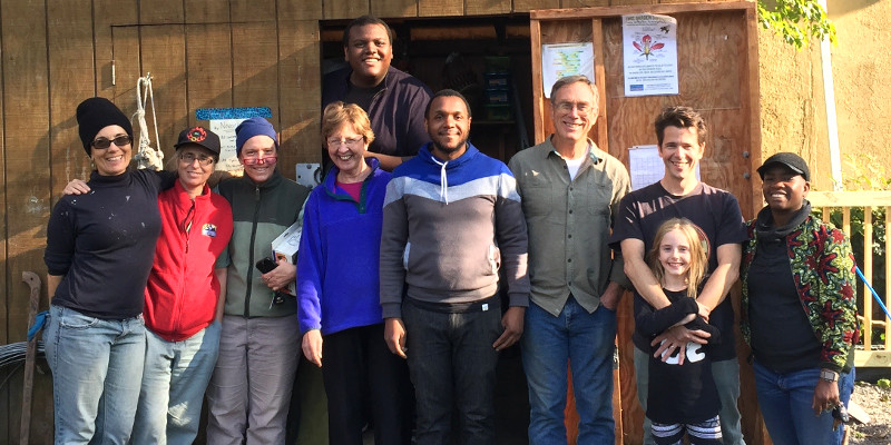 photo: smiling group of people standing near a toolshed