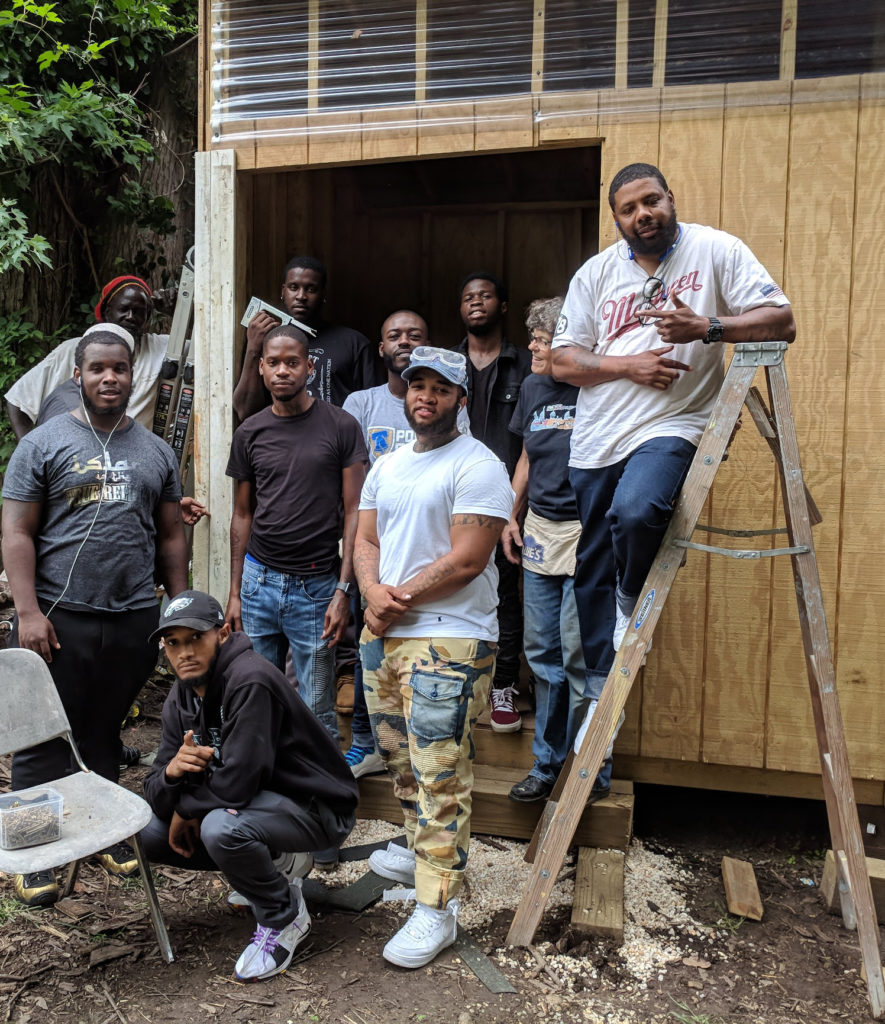 photo: group of carpenters gathered at door of shed