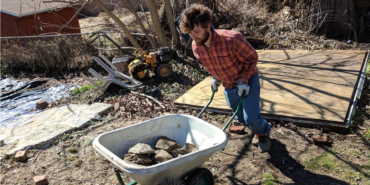 Photo: Man pushing wheelbarrow filled with stones