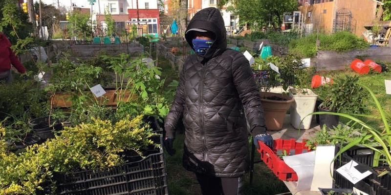 photo: heavily bundled woman with plants