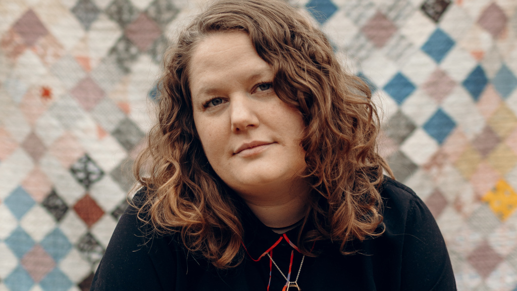photo: woman with piecework quilt backdrop