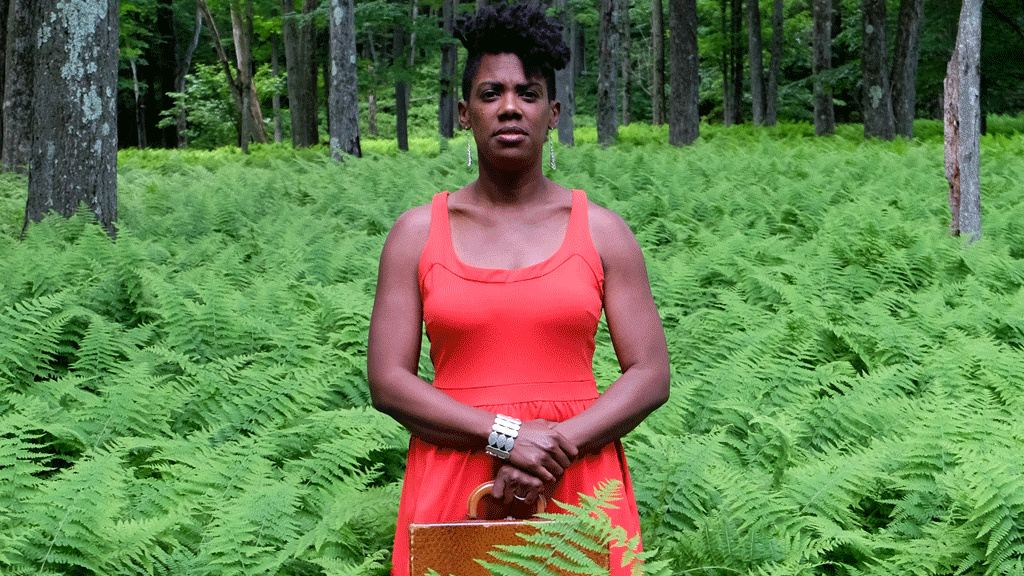 Black woman standing in a forest